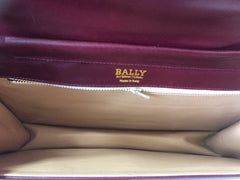 Vintage Bally wine leather clutch bag, party and classic purse with gold tone logo motif.
