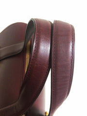 Vintage Cartier classic wine, bordeaux leather handbag purse in unique shape with bullet design gold hardware at handles. Must de Cartier