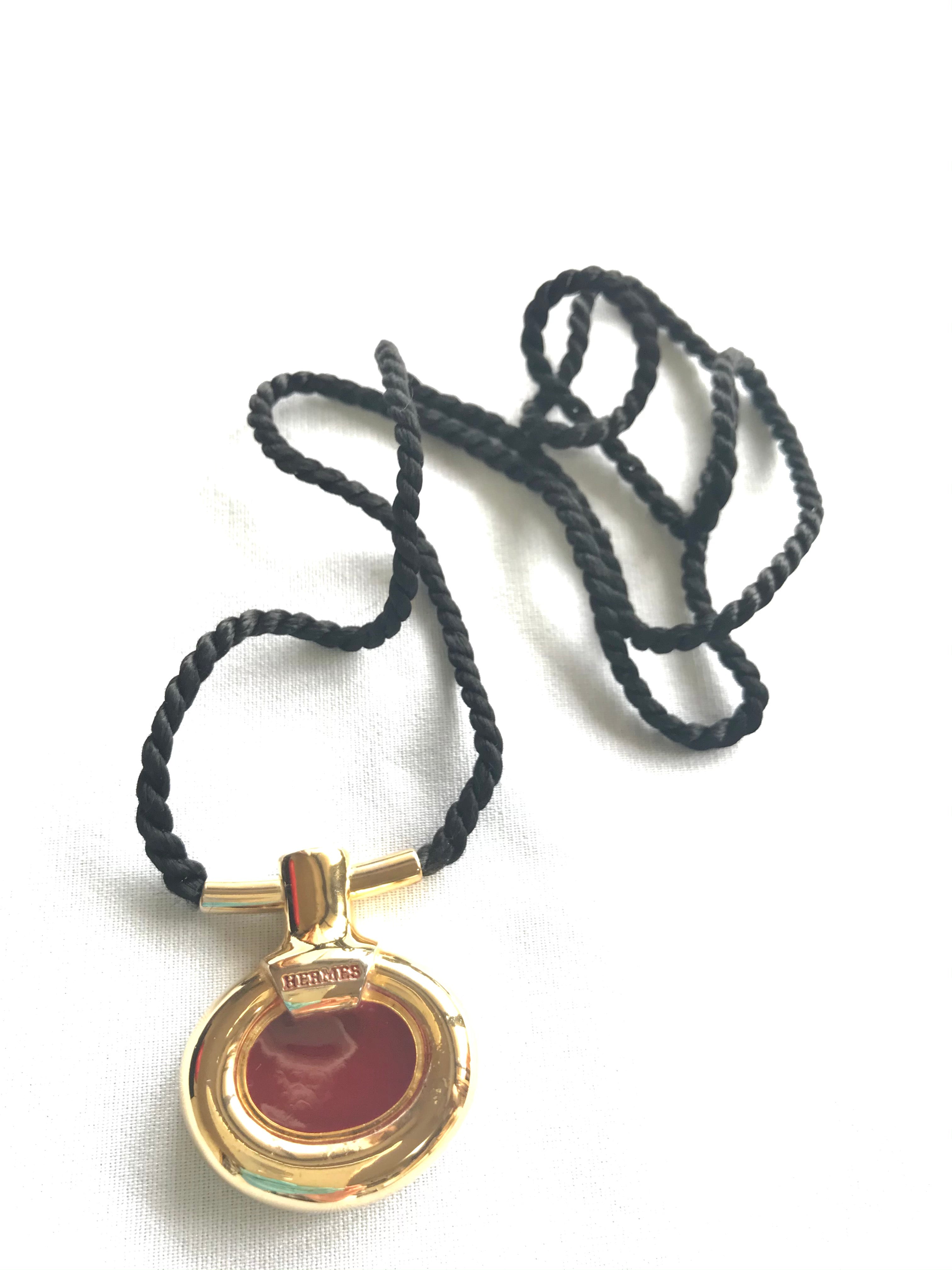 Vintage Hermes golden and red stone charm pendant top necklace with black strings. Unique jewel piece from PARFUM Collection.