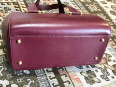 Vintage Cartier classic wine, bordeaux leather handbag purse in unique shape with bullet design gold hardware at handles. Must de Cartier
