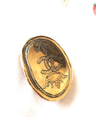Vintage CHANEL gold tone large brooch in oval coin shape with CC logo and crown embossed motif. Rare masterpiece jewelry. 060620re3