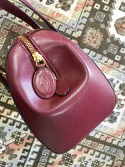 Vintage Cartier classic wine, bordeaux leather handbag purse in unique shape with bullet design gold hardware at handles. Must de Cartier