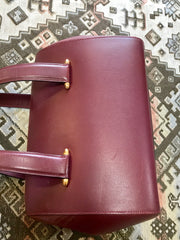 Vintage Cartier classic wine, bordeaux leather handbag purse in unique shape with bullet design gold hardware at handles. Must de Cartier