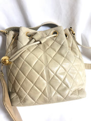 Vintage CHANEL beige quilted lamb leather hobo bucket shoulder bag with drawstrings and golden CC mark ball. 050320r3