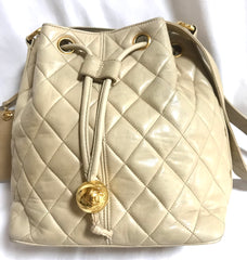 Vintage CHANEL beige quilted lamb leather hobo bucket shoulder bag with drawstrings and golden CC mark ball. 050320r3