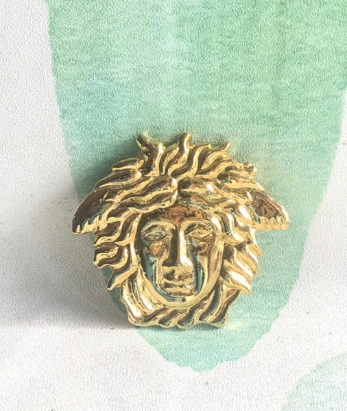 Vintage Gianni Versace gold medusa head face brooch. Can be hat