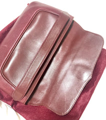 Vintage Cartier wine leather clutch bag with gold tone logo motif. Classic purse from must de Cartier Collection.