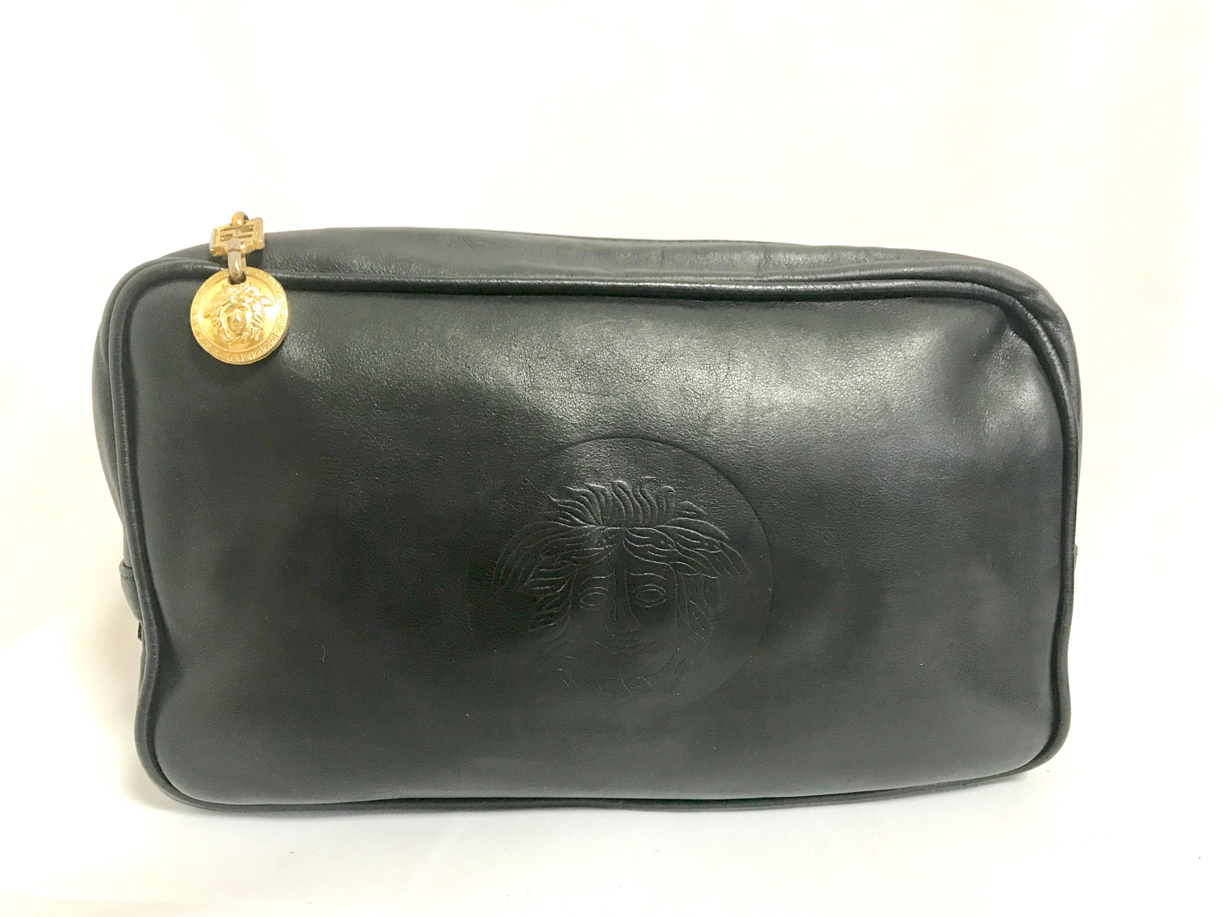 Vintage Gianni Versace black leather purse pouch, case bag with its iconic medusa face and golden logo motif charm. Unisex bag. 061122re1