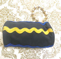 Vintage Moschino by Redwall tube shape black pouch bag with pink, green, and blue wave trimming and gold tone ball design handle. Rare, chic and mod pouch bag.