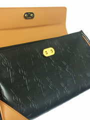 Vintage Yves Saint Laurent YSL logo embossed black leather handbag purse with brown leather trimmings and golden charm.