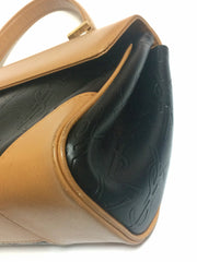 Vintage Yves Saint Laurent YSL logo embossed black leather handbag purse with brown leather trimmings and golden charm.