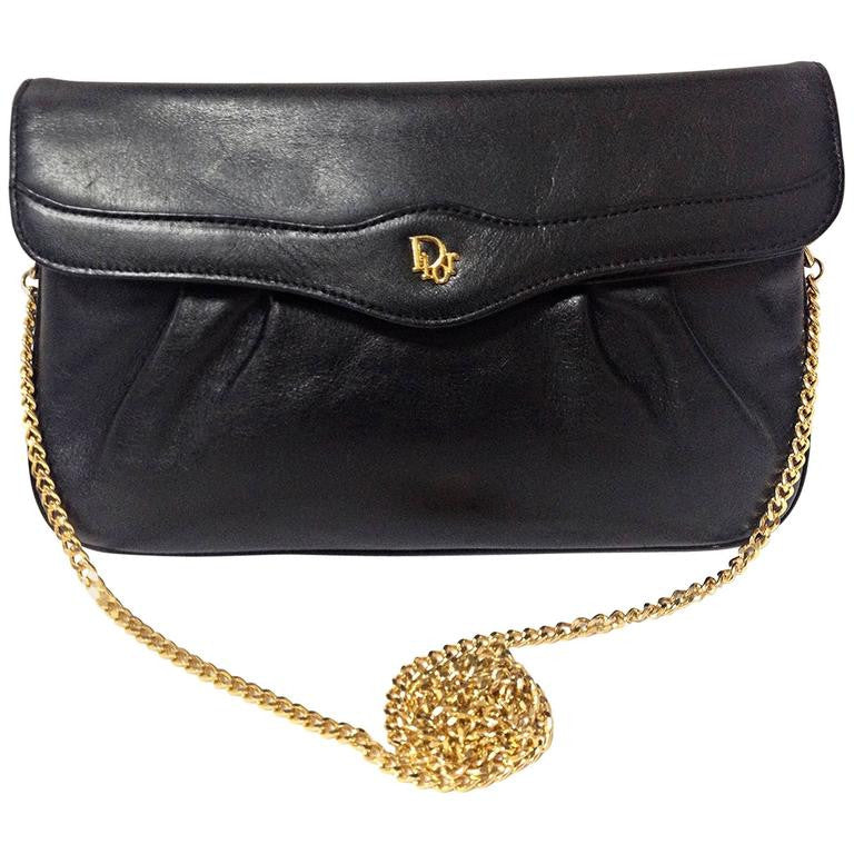 Vintage Christian Dior Vintage black leather clutch purse, mini bag, with golden Dior motif and gold tone chains.
