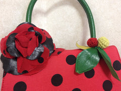 MINT. Vintage Moschino red and black canvas polkadot kelly handbag with a matching rose flower and leaf and crochet fruits motifs. 0506307