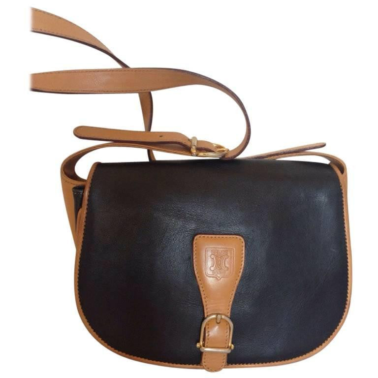 Vintage Celine black and brown genuine leather shoulder bag with an embossed logo and gold tone hardware. riri zipper