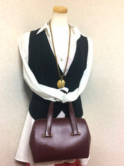Vintage Cartier classic wine, bordeaux leather handbag purse in unique shape with bullet design gold hardware at handles. Must de Cartier