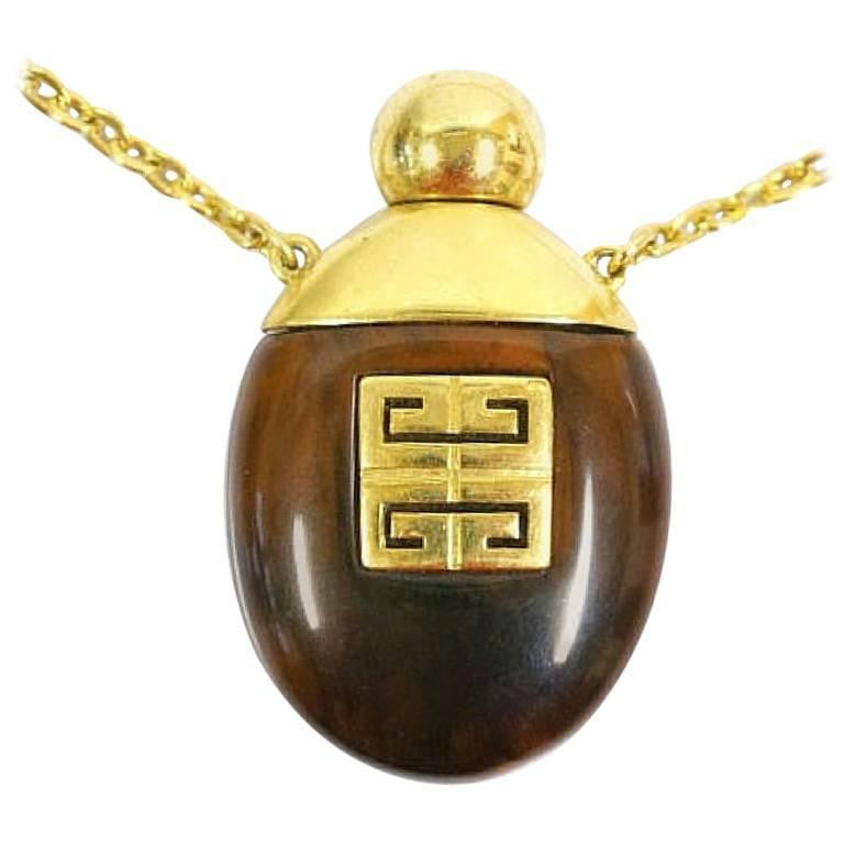 Vintage Givenchy gold chain necklace with gold tone logo motif and brown marble stone perfume bottle pendant top. Statement