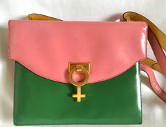 Vintage MOSCHINO pink, green, and yellow patent enamel leather shoulder bag with golden men symbol motif at closure. Masterpiece by Red wall