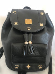Vintage MCM black backpack with golden studded logo motifs and drawstrings. Designed by Michael Cromer. Unisex bag for daily use.
