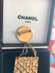 Vintage CHANEL Gold tone brooch with 2.55 classic purse and CC charms. Chic dangling brooch