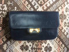 Vintage Nina Ricci navy leather clutch chain shoulder bag, classic purse with golden ribbon logo motif. Mod and chic daily purse.
