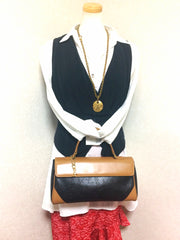 Vintage Yves Saint Laurent YSL logo embossed black leather handbag purse with brown leather trimmings and golden charm.