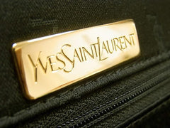 Vintage Yves Saint Laurent YSL logo embossed black leather handbag purse with brown leather trimmings and golden charm.
